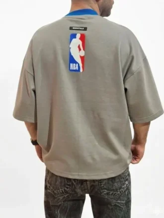 نمای پشت تیشرت NBA طوسی روی بدن مدل همراه با لوگوی بسکتبال و تگ اسنشیالز